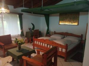 1 dormitorio con 1 cama, mesa y sillas en Dik Dik Hotel, en Arusha