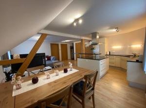 duża kuchnia i salon z drewnianym stołem w obiekcie Bodensee Wohnung 3 mit Privatstrand w mieście Gaißau