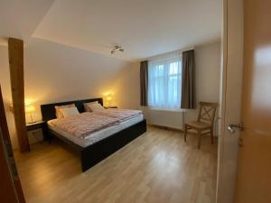 a bedroom with a bed and a chair and a window at Bodensee Wohnung 3 mit Privatstrand in Gaißau