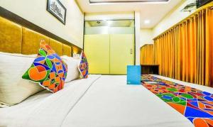 a bedroom with a large bed with colorful pillows at FabHotel Ascot International II in Mumbai