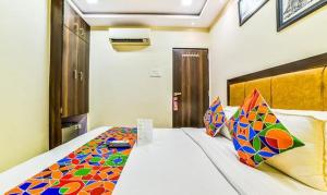 a bedroom with a bed with colorful pillows on it at FabHotel Ascot International II in Mumbai