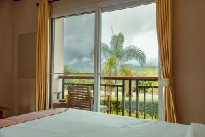 1 dormitorio con cama y vistas a un balcón en Pai happyvillage_yeon en Dhungpong