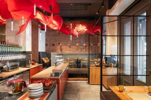 a large kitchen with red chandeliers in a restaurant at THE MANES Boutique Hotel Prague in Prague