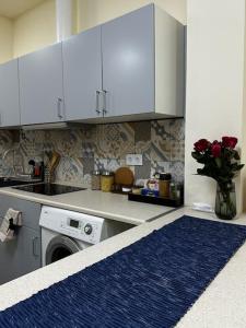 a kitchen with a washing machine and white cabinets at Kleparski 17 Apartament in Krakow