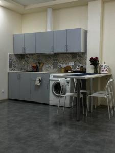 a kitchen with a table and a washing machine at Kleparski 17 Apartament in Krakow