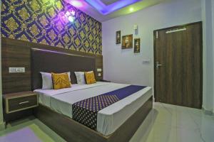 een slaapkamer met een bed en een houten deur bij SPOT ON Hotel White Rose in Zirakpur