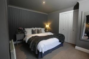 ein Schlafzimmer mit einem großen Bett in einem Zimmer in der Unterkunft The Old Talbot Hotel Milton Keynes in Potterspury