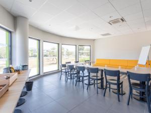 a waiting room with a long table and chairs at B&B HOTEL Saint-Martin-de-Crau Alpilles Camargue in Saint-Martin-de-Crau