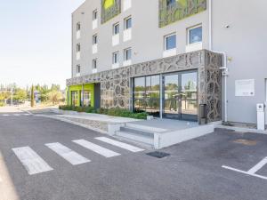 un aparcamiento vacío frente a un edificio en B&B HOTEL Saint-Martin-de-Crau Alpilles Camargue en Saint-Martin-de-Crau