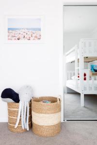 a room with a basket and a bed and a mirror at Rosebay - Coastal Holiday Home in Rosebud