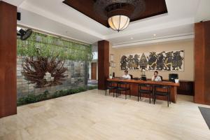 two people sitting at a bar in a hotel lobby at Amadea Resort & Villas Seminyak Bali in Seminyak