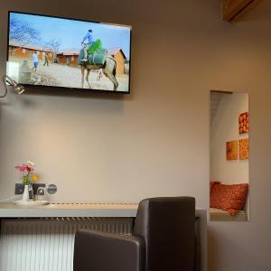ein Flachbildfernseher, der an einer Wand hängt in der Unterkunft Hotel - B&B PassaDia in Zwevegem
