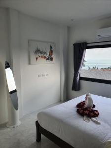 een witte slaapkamer met een bed en een raam bij duplex 2 bedroom sea view villa with private pool in Koh Samui  +5 foto's