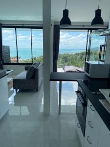 een keuken en woonkamer met uitzicht op de oceaan bij duplex 2 bedroom sea view villa with private pool in Koh Samui 