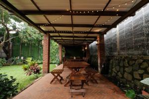 an outdoor patio with a wooden table and benches at Rumah Canda in Bandung