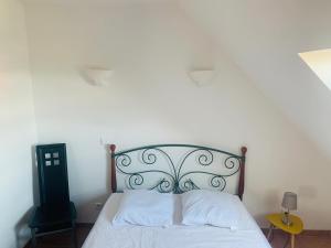 Schlafzimmer mit einem weißen Bett mit einem Kopfteil aus Metall in der Unterkunft Appartement situé prés des plages et du golf in Saint-Briac-sur-Mer