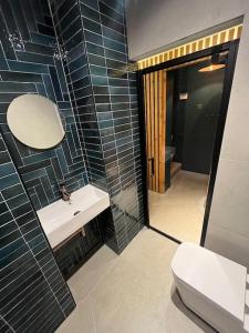 ein Badezimmer mit einem Waschbecken, einem WC und einem Spiegel in der Unterkunft The Coachhouse, Hot Tub in Henley in Arden