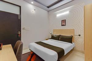a bedroom with a bed and a table with a desk at Super Collection O Govind Marg in Jaipur