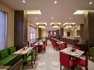 une salle à manger avec des tables et des chaises vertes dans l'établissement Daiwik Hotels Rameswaram, à Rameswaram