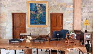 una mesa de madera en una habitación con una pintura en la pared en Grand Melka Hotel, en Lovina