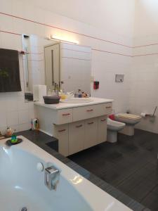 ein Badezimmer mit einer Badewanne, einem Waschbecken und einem WC in der Unterkunft Ο κόκορας in Artemida