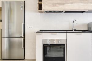 uma cozinha com um frigorífico de aço inoxidável e um lavatório em JOIVY Welcoming Studio near CityLife em Milão