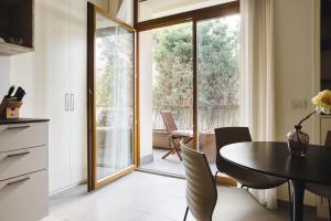 uma cozinha e sala de jantar com mesa e cadeiras em JOIVY Welcoming Studio near CityLife em Milão