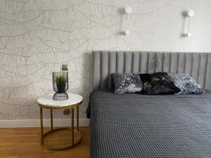 1 dormitorio con 1 cama y 1 mesa con lámpara en APARTAMENT PRZY LESIE, en Cracovia