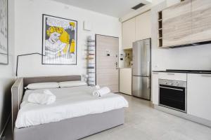 uma cozinha com uma cama grande num quarto em JOIVY Welcoming Studio near CityLife em Milão