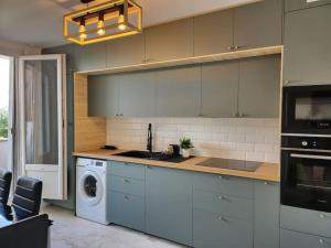 a kitchen with a sink and a washing machine at Appartement Spacieux et Rénové in Neuilly-sur-Marne