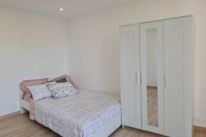 um quarto branco com uma cama e um armário em Appartement Spacieux et Rénové em Neuilly-sur-Marne