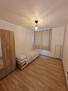 um quarto vazio com uma cama e uma porta em Appartement Spacieux et Rénové em Neuilly-sur-Marne