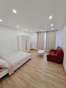 um quarto com uma cama e uma cadeira vermelha em Appartement Spacieux et Rénové em Neuilly-sur-Marne