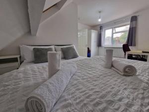 een slaapkamer met een groot bed en handdoeken bij Nice Living Serviced Accommodations 9 (King-Size Studio Flat + Kitchen) in Coventry