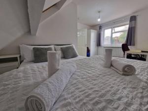 a bedroom with a large bed with towels on it at Nice Living Serviced Accommodations 9 (King-Size Studio Flat + Kitchen) in Coventry