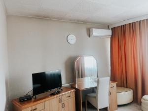um quarto de hotel com uma televisão e uma secretária com uma cadeira em Motel Dačo em Vitez