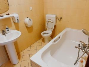 uma casa de banho com um WC, um lavatório e uma banheira em Motel Dačo em Vitez