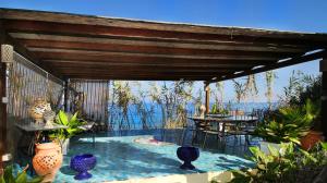 un patio con mesas y jarrones encima en BOUTIQUE VILLA con accesso privato alla spiaggia en Caronia