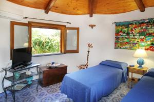 um quarto com uma cama e uma televisão e uma pintura de girafa em BOUTIQUE VILLA con accesso privato alla spiaggia em Caronia