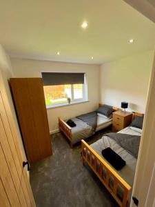 1 dormitorio con 2 camas y sofá en Modern bungalow in good location, en Aberdulais