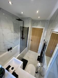 a white bathroom with a shower and a toilet at Modern bungalow in good location in Aberdulais