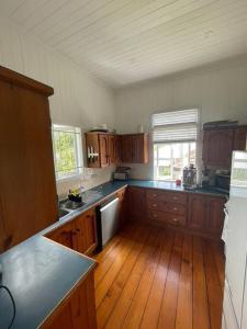 a large kitchen with wooden floors and wooden cabinets at Neat, Tidy and Central in Brisbane