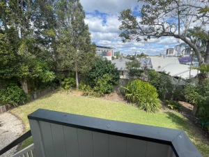 Elle offre une vue sur une cour dotée d'une clôture blanche et d'herbe. dans l'établissement Neat, Tidy and Central, à Brisbane