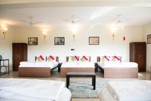 Habitación grande con 2 camas y mesa. en Olive Resort - Sillari Pench en Silāri
