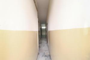 a hallway with a white wall and a door at SPOT ON Motel Haryana in Chandīgarh