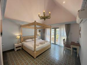 una camera con letto a baldacchino e lampadario pendente di S2 Beach Cottages a Morjim