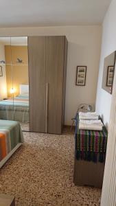 a bedroom with a bed and a cabinet with a mirror at Apartment Obici in Spilamberto