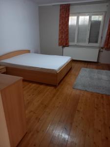 um quarto com uma cama e piso em madeira em Spacious home em Gödöllő