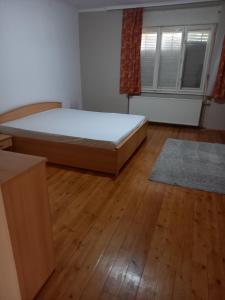 1 dormitorio con 1 cama y suelo de madera en Spacious home, en Gödöllő