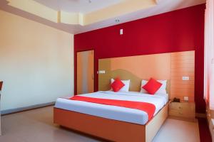 um quarto com uma cama grande e paredes vermelhas em Flagship Hotel Samar Palace em Jaipur